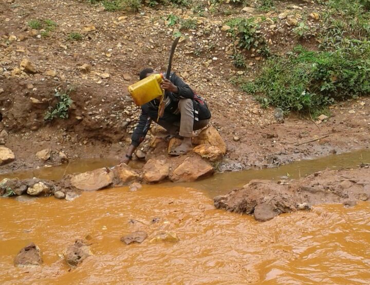 A boy fetching water from downstream of MIDROC Gold Mine’s tailing dam