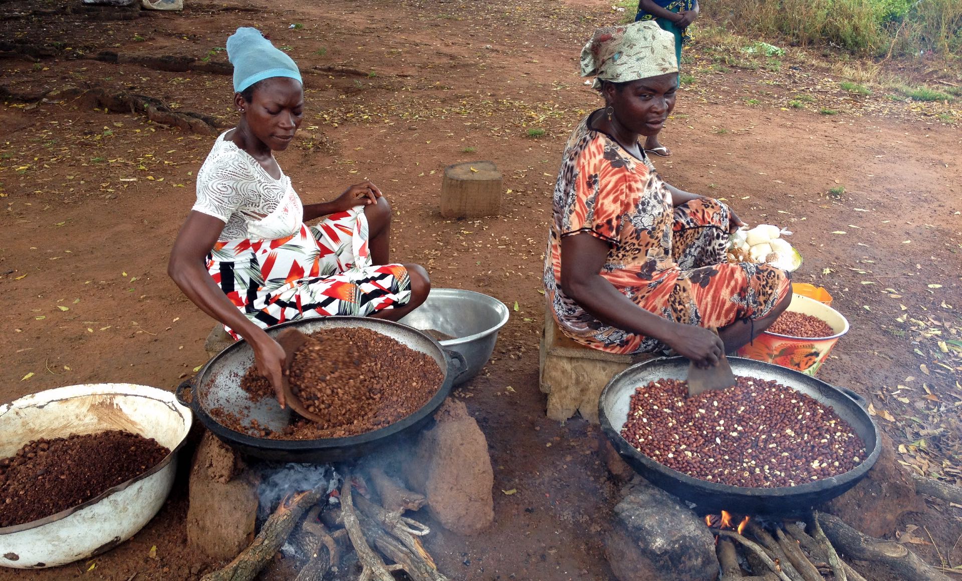 Two women roasting shea and ground nuts in Murugu, Ghana